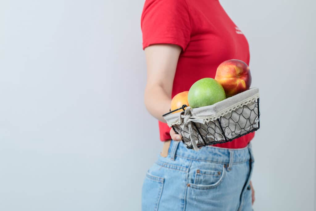 West Texas Bariatrics Gastric Sleeve Patient Holding A Basket of Apples While on a Pouch Reset Diet